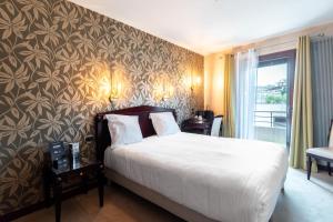 ein Hotelzimmer mit einem Bett und einer Wand in der Unterkunft Contact Hôtel Des Deux Moulins Limoges, Proche de la gare in Limoges + 44 Fotos