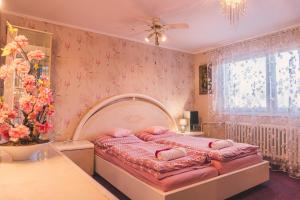 a bedroom with a bed with pink pillows on it at Dům cestovatele in Uherský Brod