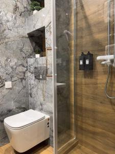 a bathroom with a toilet and a glass shower at Копа Баварія - Львів Готель in Pasiky-Zubryts'ki +45 photos