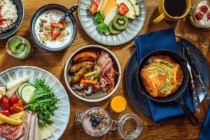 a wooden table with plates of food on it at Solo Sokos Hotel Helsinki in Helsinki