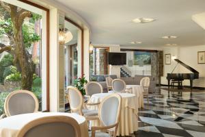 a restaurant with tables and chairs and a piano at Hotel Cenobio Dei Dogi in Camogli