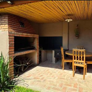 a patio with a fireplace and a table and chairs at Casa Raíz 2 habitaciones para 4 personas frente al río in Santa Rosa de Calamuchita