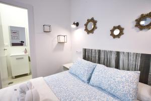 a bedroom with a bed with blue pillows and mirrors at Cuencaloft El 3 in Cuenca