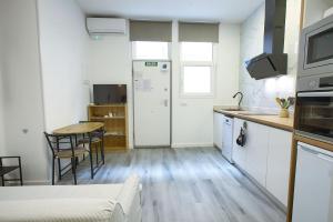 a small kitchen with a table and a refrigerator at Cuencaloft El 3 in Cuenca
