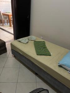 a bed with a green blanket on top of it at casa tres quartos condominio aeroporto lazer praias mercados a poucos minutos in Salvador