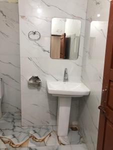 a white bathroom with a sink and a mirror at Hotel Him darshan in Madheso