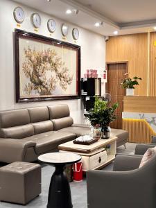 a living room with a couch and a painting on the wall at Khách sạn Vin Hồ in Thế Rương