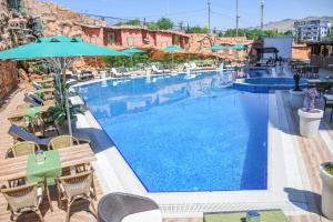 a large swimming pool with chairs and umbrellas at Dilshad Palace Hotel in Duhok
