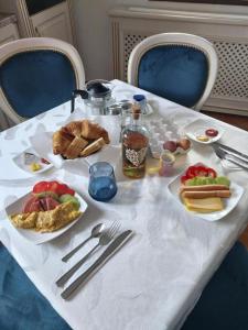 a white table with plates of food on it at Serafim's Suites Airport in Iaşi