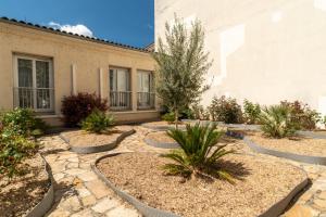 ein Garten mit Steinen und Pflanzen vor einem Gebäude in der Unterkunft Contact Hôtel Des Deux Moulins Limoges, Proche de la gare in Limoges