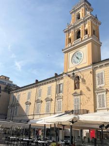 a large building with a clock tower on top of it at Aura Suite in Parma