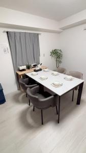 a dining room table with chairs and a white table and chairsktop at カリエンテ三宮202 in Kobe