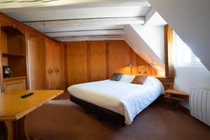 a bedroom with a bed and a desk in a room at Hotel Restaurant Père Benoît in Entzheim
