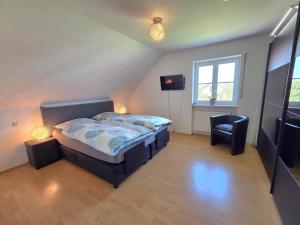ein Schlafzimmer mit einem Bett und einem Stuhl in der Unterkunft Lampl Haus in Steindorf