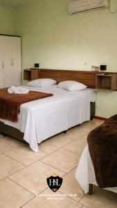a bedroom with two beds in a room at Hotel São Luiz Iraí in Iraí