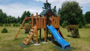 a wooden playset with a slide and a slideintend at Ferienwohnung Mohnblume in Gerswalde