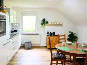 a kitchen with a table and a dining room at Ferienwohnung Schwarzhof- Hahnekräh am Bostalsee, helle 75 qm & hundefreundlich in Nohfelden