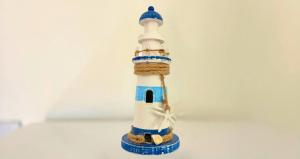 a small figurine of a lighthouse sitting on a table at Dimora Mary - Vicino al mare in La Maddalena