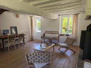 a living room with a table and chairs at Le Clos du Avre - Maison calme & jardin verdoyant in Breux-sur-Avre