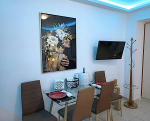 a dining room with a table and a tv on a wall at Sun Suite in Sitia