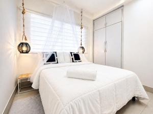 a white bedroom with a white bed and a window at Casa Vacacional Playa del Sur in Chichiriviche +35 photos