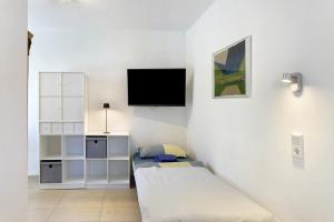 a room with a bed and a tv on a wall at Belvedere-Remise in Weimar