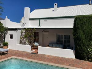 a house with a swimming pool in front of a house at Maison Fougere in Franschhoek