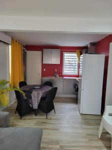 a kitchen with a table and chairs in a room at Hibiscus holiday in Capesterre-Belle-Eau
