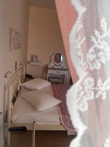 a small bedroom with a bed and a washing machine at Isidora Hotel in Agia Marina Aegina