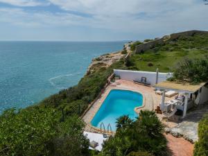 an image of a swimming pool next to the ocean at Refugio in Carvoeiro