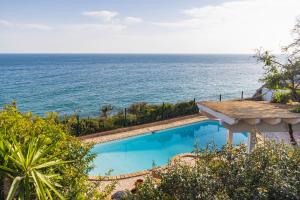 a swimming pool with the ocean in the background at Refugio in Carvoeiro +77 photos