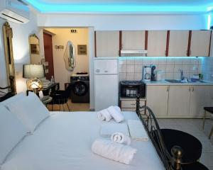 a bedroom with a white bed and a kitchen at Sun Suite in Sitia +29 photos