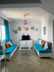 a living room with two beds and a tv at Duplex Marina Monastir in Monastir
