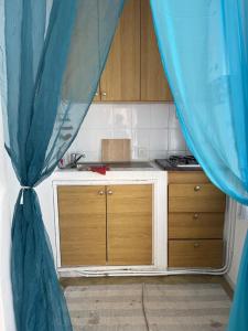 a kitchen with a counter and a blue curtain at Duplex Marina Monastir in Monastir