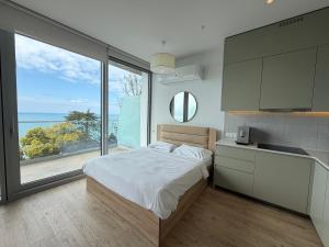 a bedroom with a bed and a view of the ocean at Green Cape Botanico in Batumi +135 photos