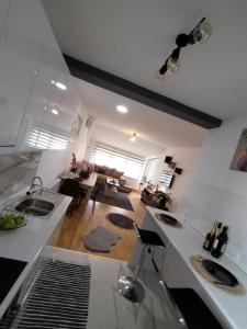 a kitchen with two sinks and a living room at Allegra lux in Sombor