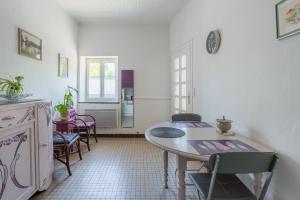 a kitchen with a table and chairs in a room at Maison T2 - Le Boichot in Dole