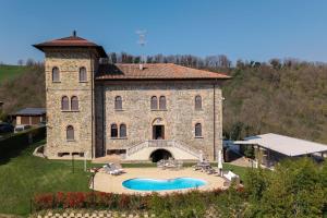 a large stone building with a pool in front of it at Tenuta Il Poggio - Luxury B&B in Felegara