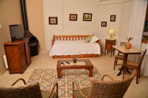 a bedroom with a bed and a table and chairs at Hotel fazenda do Cedro in Areal