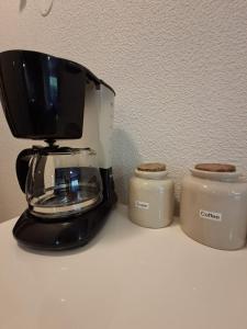a coffee maker and two jars on a counter at Le 540 - Annecy - Parking in Annecy