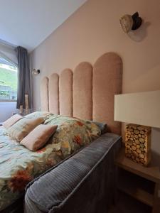 a bedroom with a bed with a large padded headboard at Le 540 - Annecy - Parking in Annecy