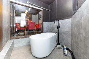 a bathroom with a white tub and a dining room at Nagoya JADE GRACE in Nagoya