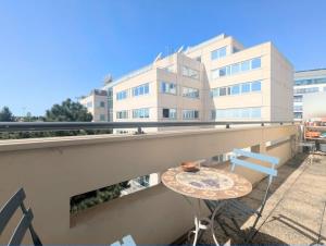 a table and chairs on a balcony with a building at Bel appartement balcon - 2 personnes in Malakoff