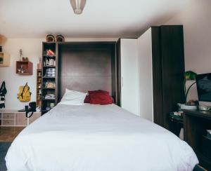 a bedroom with a large white bed with a black headboard at Bel appartement balcon - 2 personnes in Malakoff