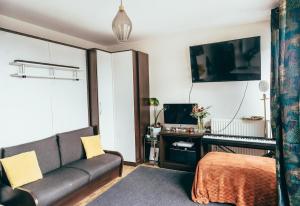 a living room with a couch and a desk at Bel appartement balcon - 2 personnes in Malakoff