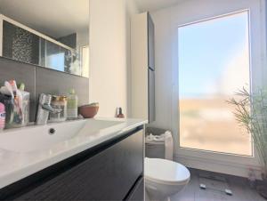 a bathroom with a white sink and a toilet at Bel appartement balcon - 2 personnes in Malakoff +10 photos