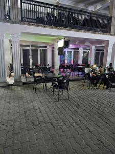 a large room with tables and chairs and a television at Trapezium Lodge in Amasaman
