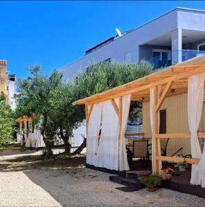 a house with a pergola in front of it at Camp Phoenix in Srima