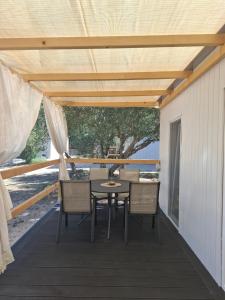 a patio with a table and chairs under awning at Camp Phoenix in Srima