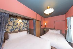 two beds in a room with red walls at Nagoya JADE GRACE in Nagoya +52 photos